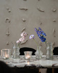 Photo avec des vases fleuris et des bougeoirs sur une table en marbre