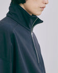 zoom sur le col du pull bleu marine sur mannequin