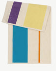 Serviette de plage de la marque Suite 702 de couleur bleu orange jaune et violet