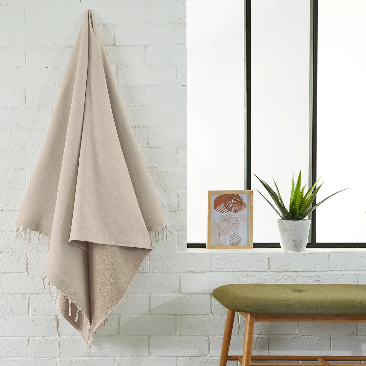 Foutas éponge unie beige sahara étendue dans une salle de bain