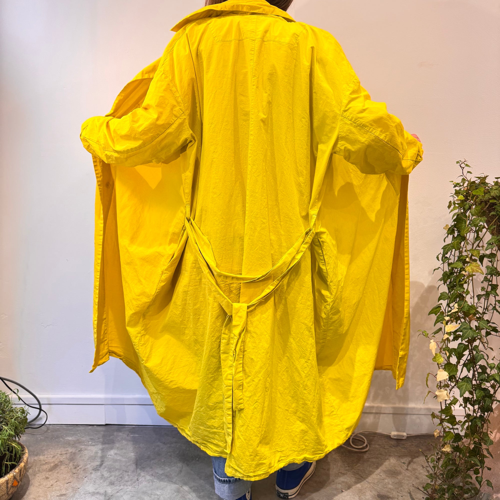 Trench avec les bras ouverts de dos